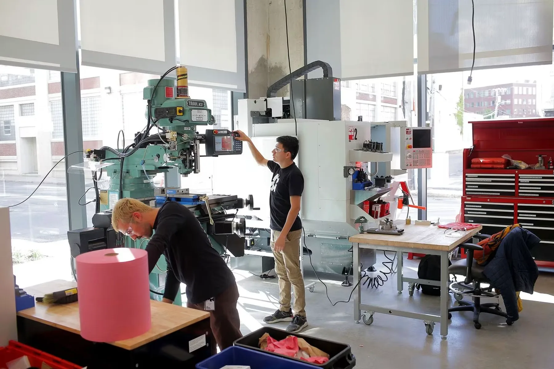 Engineers worth with heavy fabrication equipment and rapid prototyping tools in The Engine's machine shop.